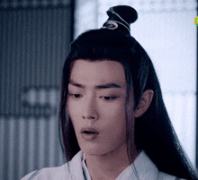 a close up of a man 's face with a bun on his head