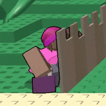 a person in a pink hat is sitting behind a fence