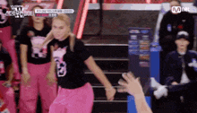 a woman in a number 8 shirt is dancing in front of a crowd