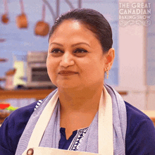 a woman wearing an apron and earrings is smiling for the great canadian baking show