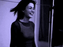 a woman in a black shirt is smiling in a black and white photo