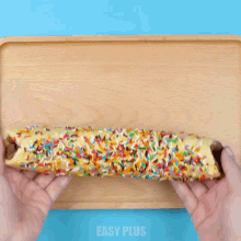 a person is cutting a cookie roll with sprinkles