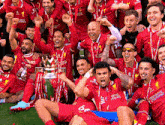a group of soccer players are posing for a picture with a trophy that says standard chartered