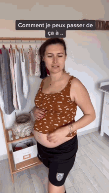 a pregnant woman stands in front of a rack of clothes and a sign that says comment je peux passer de ca a..