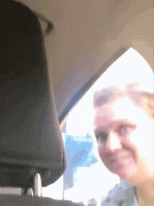 a woman is sitting in the back seat of a car smiling