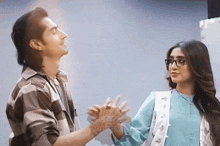 a man and a woman are holding hands and looking up at each other
