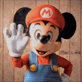 a mickey mouse mascot dressed as mario is waving his hand