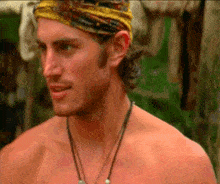 a shirtless man wearing a yellow headband and a necklace