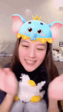 a woman wearing a blue and pink elephant hat