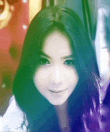 a woman with long dark hair looks at the camera and smiles