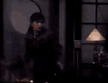 two men are sitting at a table in a dark room and talking to each other .