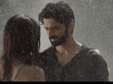 a man and a woman standing in the rain looking at each other