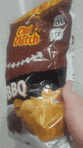 someone is holding a bag of old dutch bbq potato chips