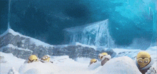 a group of minions are laying in the snow in front of a mountain .