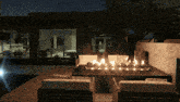 a fire pit is lit up in front of a house at night