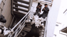 a group of men are standing on a set of stairs and one of them is a monster