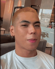 a young man with a shaved head wearing sunglasses