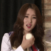 a close up of a woman holding a ball in her hand .