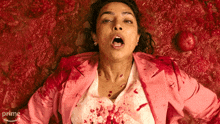 a woman in a pink jacket is covered in blood and the word prime is on the bottom of the image