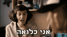 a woman with a bun on her head is screaming in hebrew