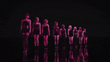 a group of girls are standing in a row in a dark room