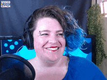 a woman wearing headphones is smiling in front of a screen that says video conference coach