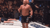 a man in a boxing ring with a crowd behind him and a sign that says ' ufc ' on it