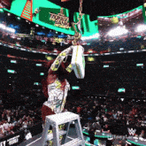 a woman in a money bank outfit stands on a ladder holding a trophy