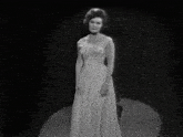 a black and white photo of a woman in a dress