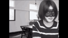 a woman wearing a black and white striped shirt with a black face paint