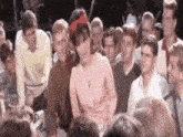 a woman in a pink dress is dancing in a crowd of people .