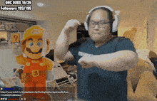 a man flexes his muscles in front of a mario mascot