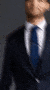 a blurry picture of a man in a suit and tie talking on a cell phone