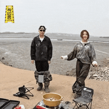 a man and a woman standing next to a yellow sign that says kyojin