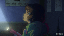 a girl is holding a flashlight in a dark room with a netflix logo in the corner