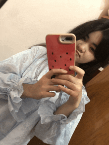 a girl is taking a selfie with her phone in a red case