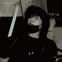 a blurry picture of a person wearing a black mask and a hoodie .