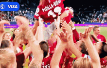 a soccer player wearing a padilla jersey is being lifted in the air by fans
