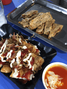 a plate of food with ketchup and mayonnaise on it sits next to a tray of food