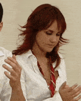 a woman with red hair is wearing a white shirt and tie