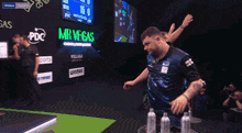 a man wearing glasses is screaming in front of a dart board that says wicken