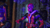 a man in a spiderman costume is standing in front of a building in a city .