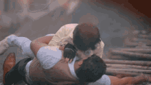a man is laying on the ground while another man holds him up in the air