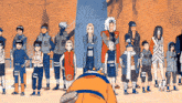 a group of people are standing in a line and one of them is wearing a jacket that says ' naruto ' on it