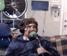a man wearing headphones is sitting on a couch with a microphone