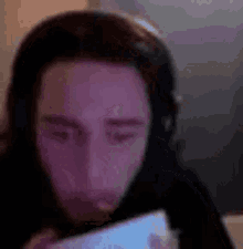 a man wearing headphones is looking at a phone .