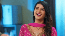 a woman in a pink dress is smiling with her mouth open