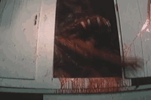 a bloody monster is crawling out of a door