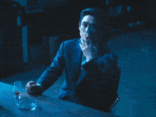 a man in a suit and tie smoking a cigarette