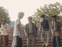 a group of young men are standing on a set of stairs and one of them has a sign that says " wanted "